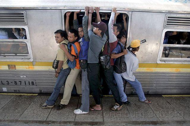 vazze_106.jpg - Indonesian men struggle to board a packed commuter train at a station in Jakarta, Indonesia Tuesday, May 11, 2010. (AP Photo/Irwin Fedriansyah)