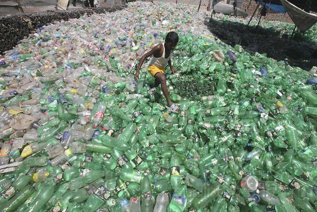 vazze_107.jpg - A boy walks through a plastic junkyard in Togga village of the northern Indian state of Punjab May 11, 2010. Emissions rose to 1.9 billion tonnes in 2007 versus 1.2 billion in 1994, with the industrial and transport sectors upping their share in Asia's third largest economy and confirming India's ranking among the world's top five carbon polluters. REUTERS/Ajay Verma (INDIA - Tags: ENVIRONMENT BUSINESS TRANSPORT)